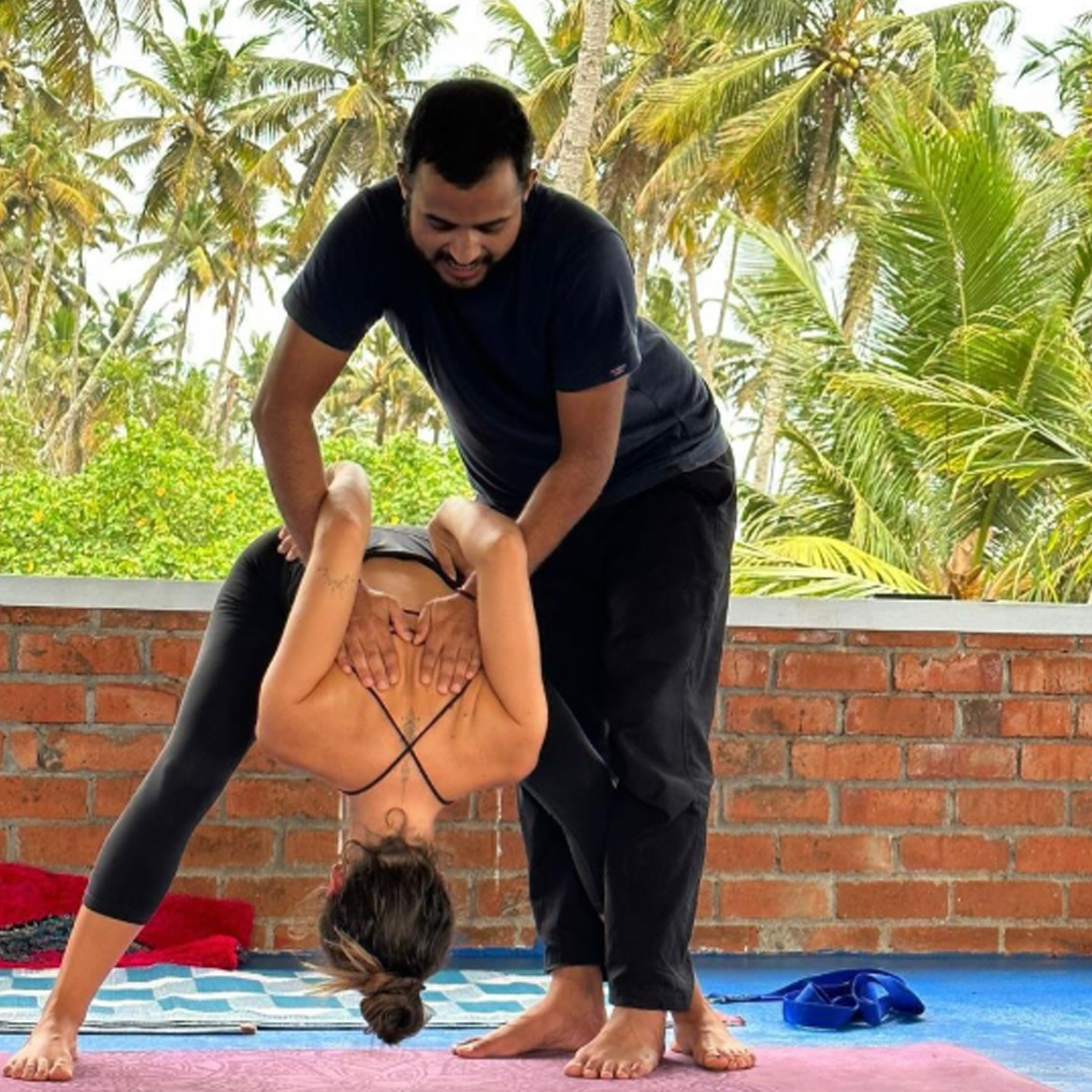 yoga teacher teaching yoga to student